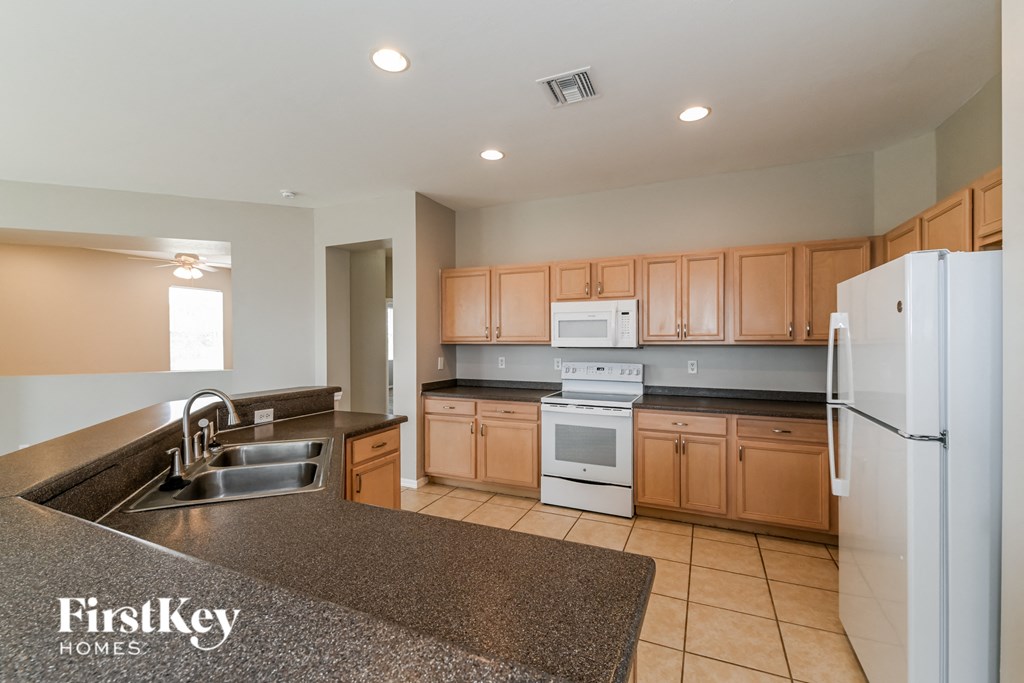 a kitchen with granite counter tops and wooden cabinets
