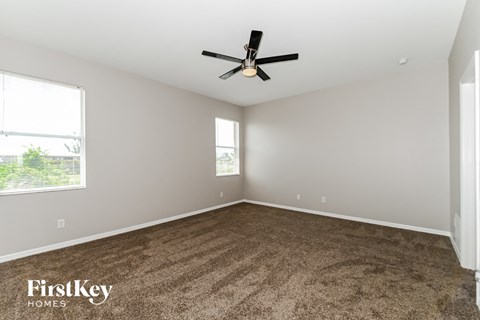 a living room with carpet and a ceiling fan