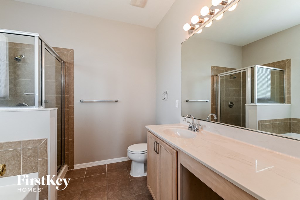 a bathroom with a large mirror and a toilet and a shower
