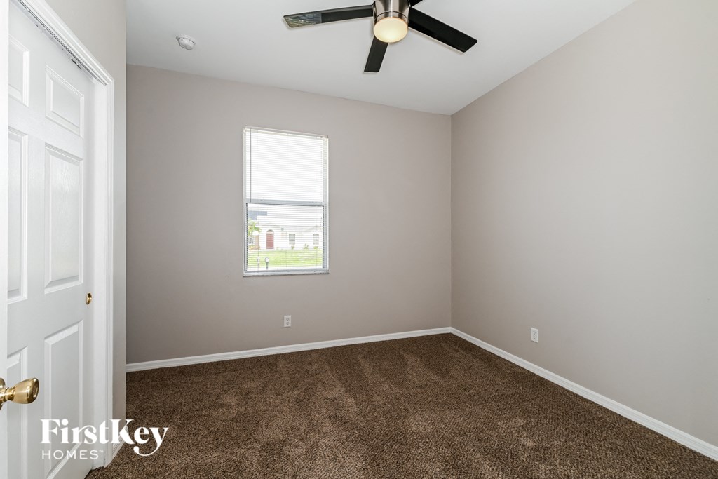 a bedroom with carpet and a ceiling fan