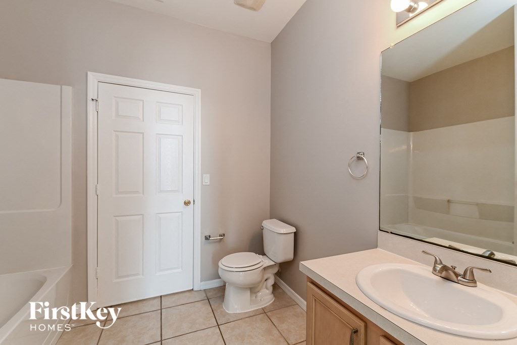 a bathroom with a toilet and a sink and a mirror
