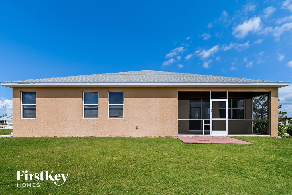 a house with a grassy yard and a blue sky