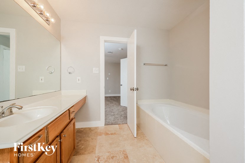 a bathroom with a tub and a sink and a mirror