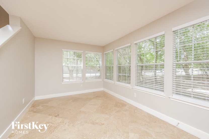 an empty room with large windows and tiled flooring