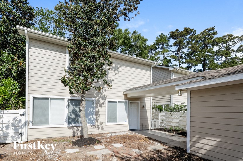a small white house with a tree in front of it