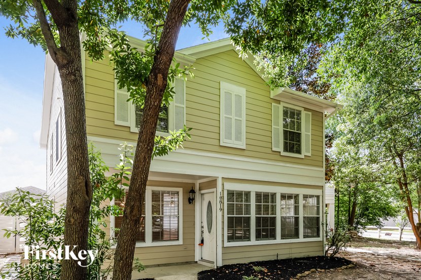 a yellow house with a tree in front of it