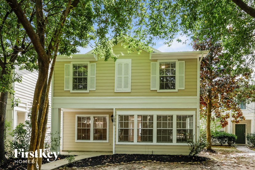 a yellow house with trees in front of it