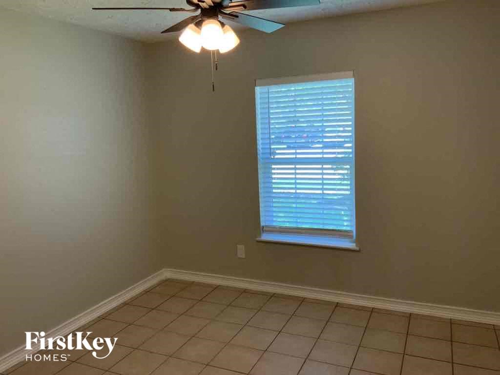 a living room with a ceiling fan and a window