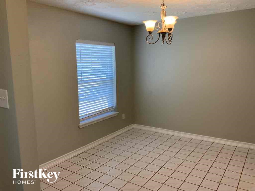 an empty living room with a tile floor and a window
