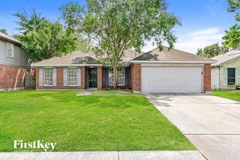 a brick house with a lawn and a white garage door