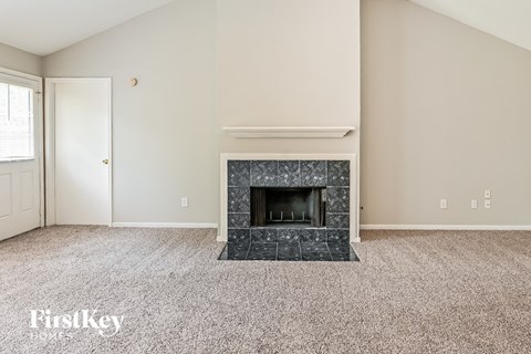 the living room has a fireplace and carpeted flooring