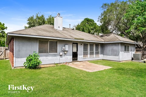 a small gray house with a yard and grass