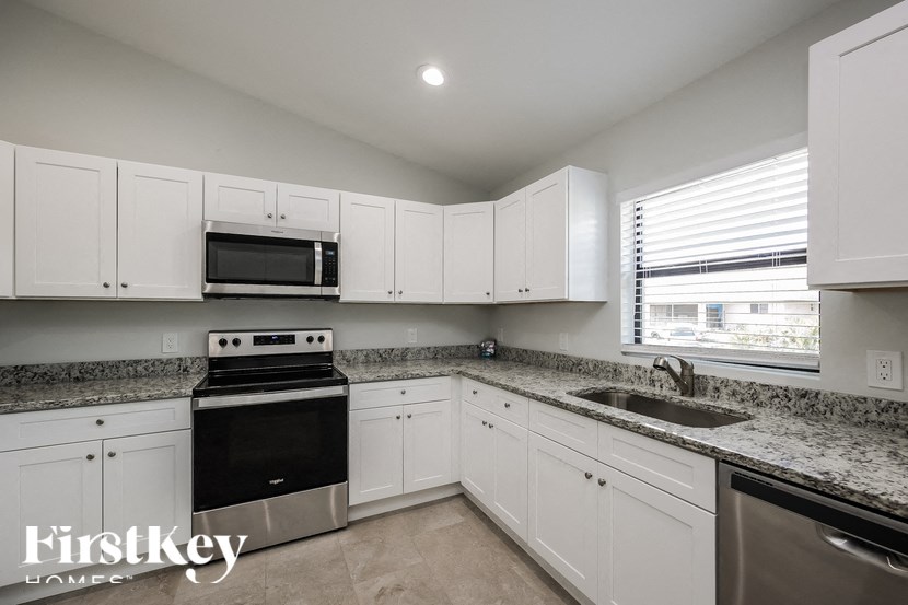 a kitchen with granite counter tops and white cabinets