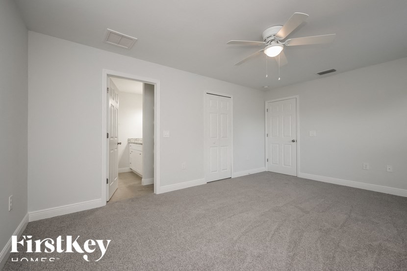 an empty living room with a ceiling fan