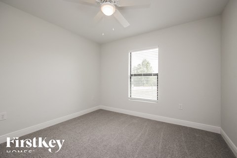 a bedroom with a ceiling fan and a window