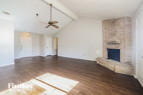a living room with a fireplace and a ceiling fan