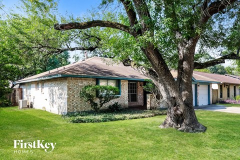 A tree in front of a house with the words "FirstKey Homes" on the bottom left.