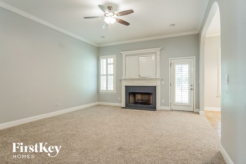 a living room with a fireplace and a ceiling fan