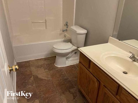 A bathroom with a toilet, sink and tiled floor.