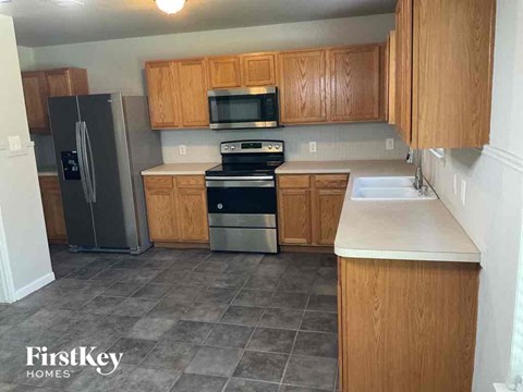 A kitchen with wooden cabinets and a tile floor.
