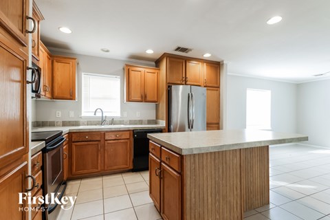 A kitchen with wooden cabinets and a refrigerator.