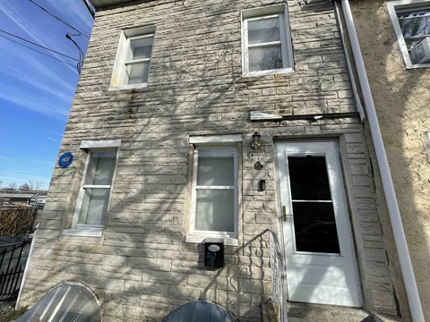 A stone building with a window and a door.