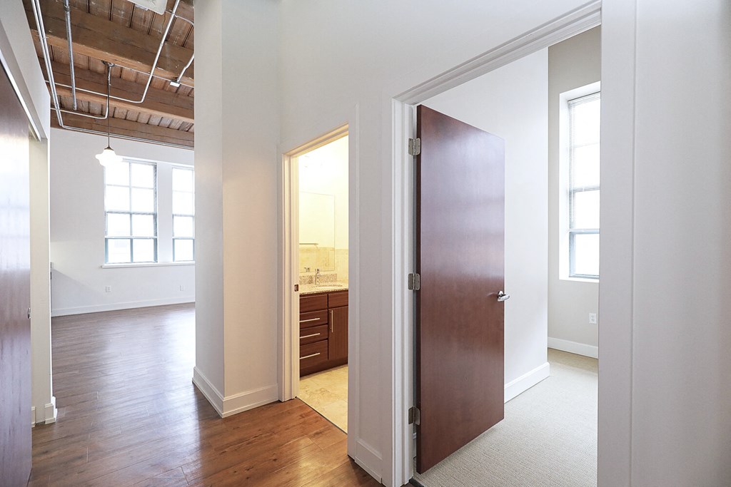 an empty living room with a door to a bathroom