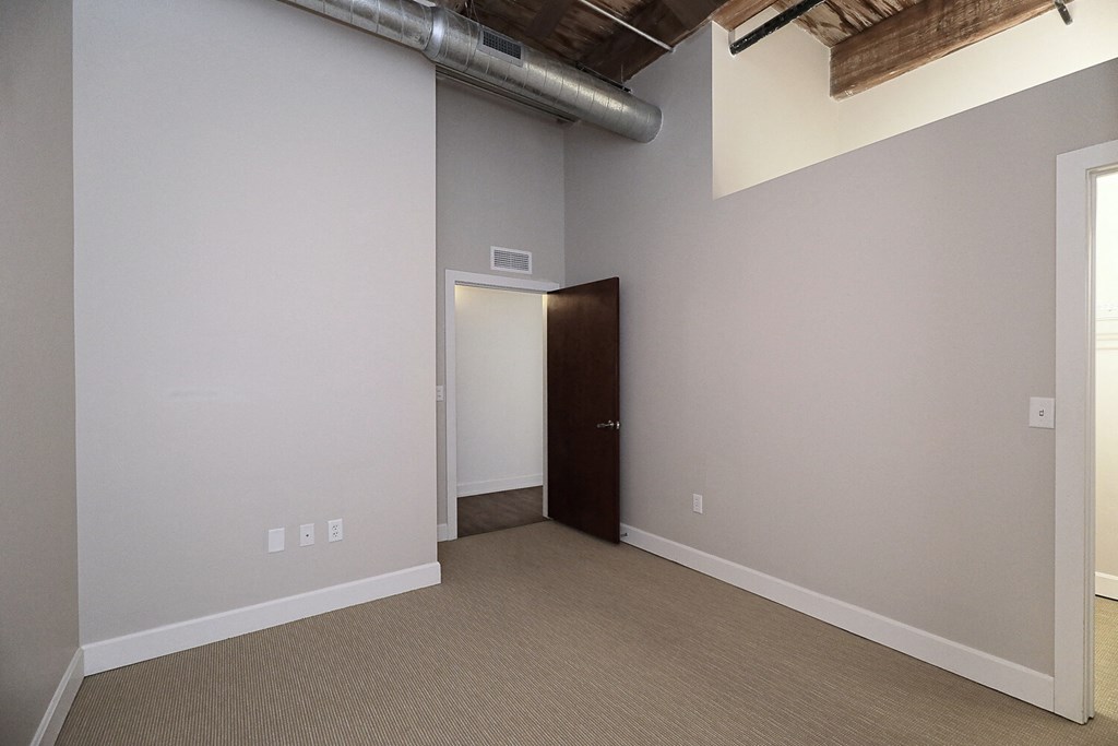 an empty living room with a door to a closet