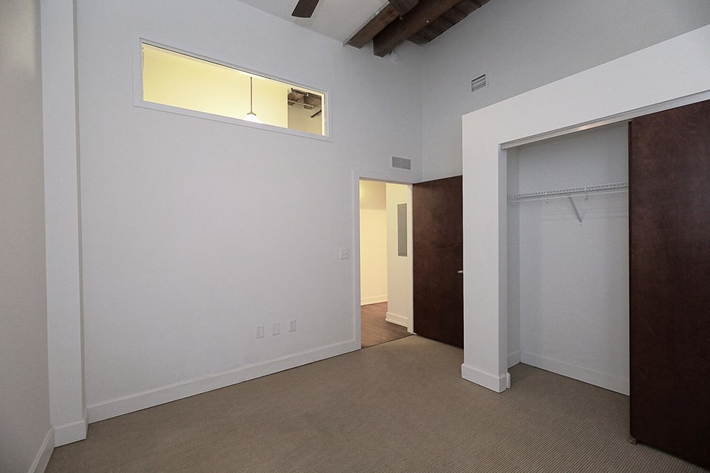 an empty room with a closet and a door to a bathroom