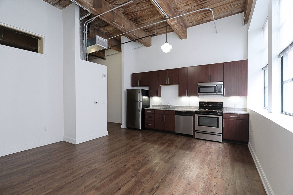 an empty kitchen with wood flooring and a large window