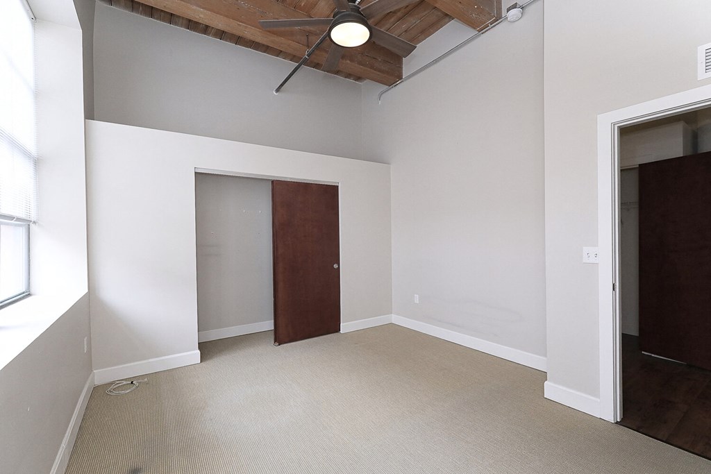 an empty room with a closet and a ceiling fan