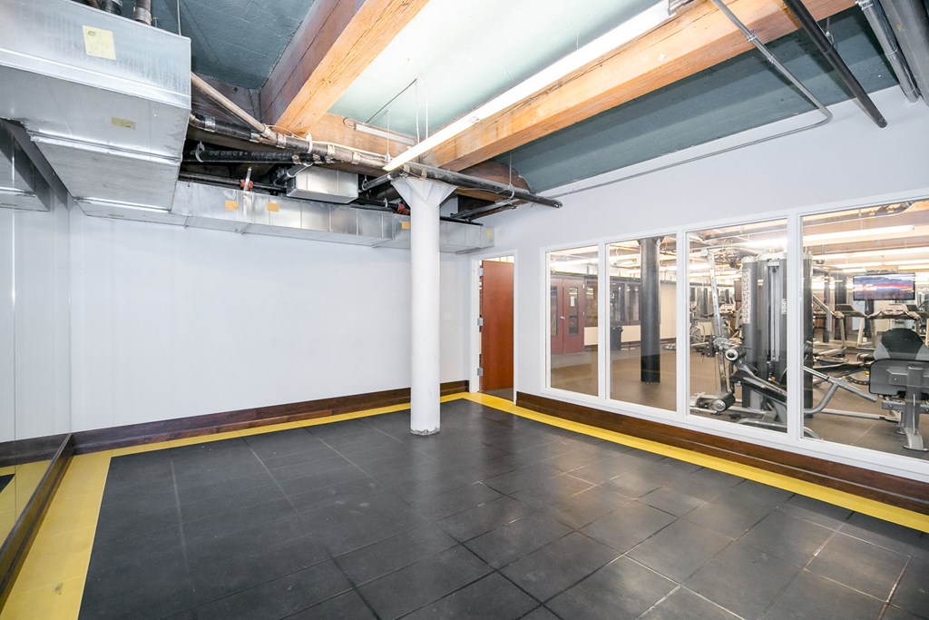 a large room with glass windows and a gym in the back