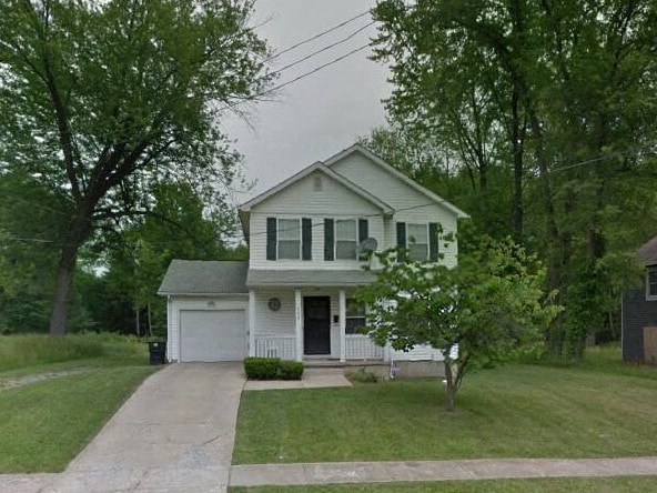 a white house with a tree in the yard