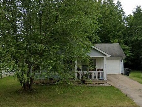 A small white house with a grey roof and a white picket fence.