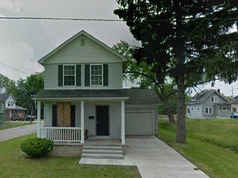 A house with a boarded up window.
