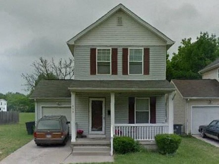 A house with a brown car parked in front.