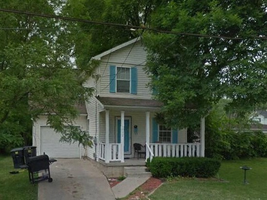 a small white house with blue doors and a porch