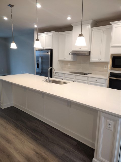 a kitchen with a white counter top and a sink