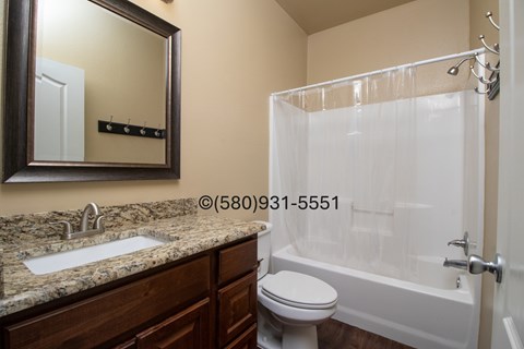 A bathroom with a sink, toilet, and bathtub.