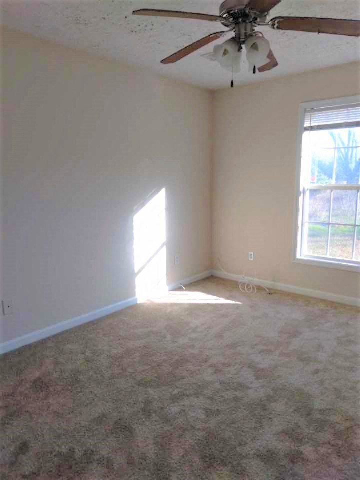 an empty room with a ceiling fan in it