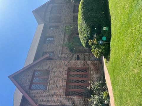 an aerial view of a building with a grass field