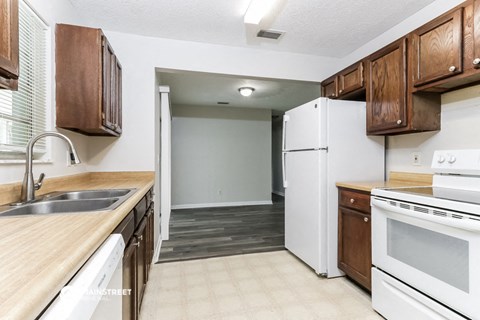 a kitchen with white appliances and wooden cabinets and a white refrigerator