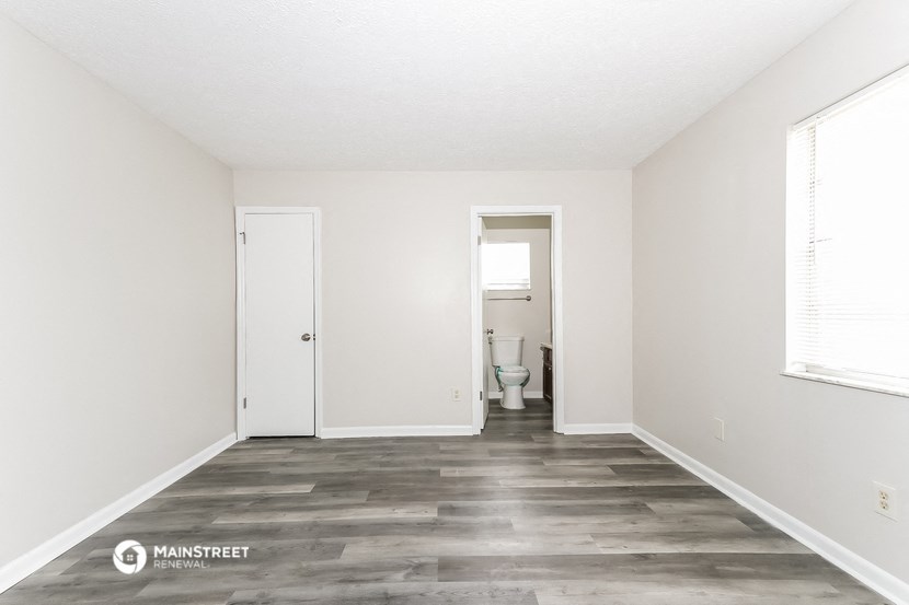 a clean and empty room with white walls and a toilet