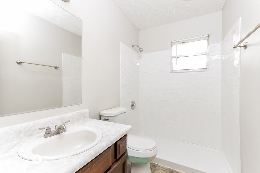 an empty bathroom with a sink toilet and shower