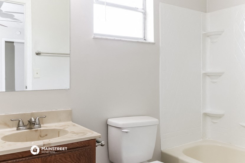 a bathroom with a toilet and a sink and a window
