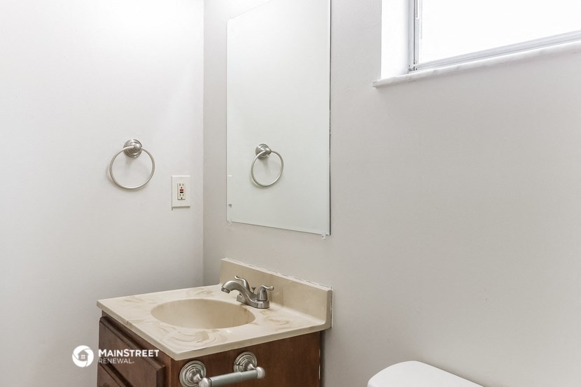 a bathroom with a sink and a mirror and a window