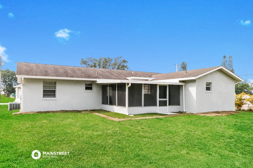 a white house with a green lawn and a blue sky