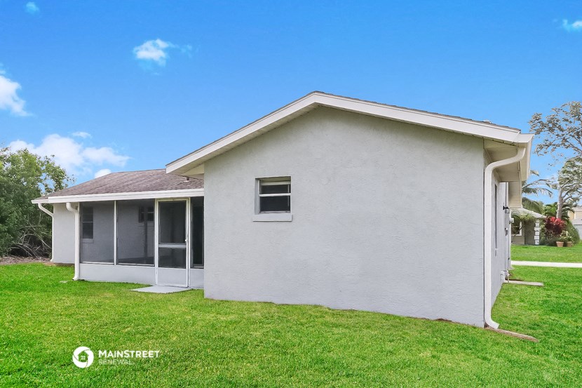 a white house with a lawn and a blue sky