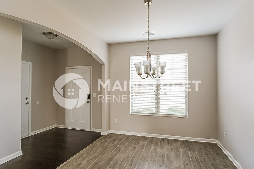 a living room with a door and a chandelier