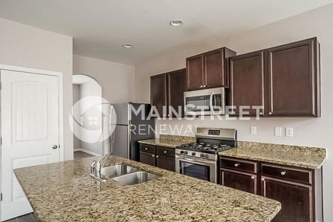 a kitchen with granite counter tops and wooden cabinets